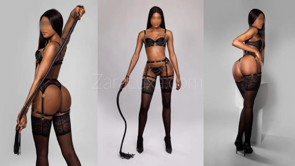 Mistress Zara posing with a whip